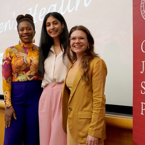 Three woman standing in front of classroom