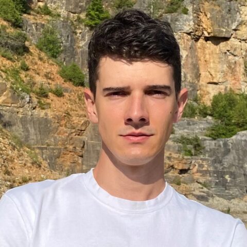 Man outside in front of brown and green terrain