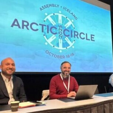 4 people sitting at conference table presenting