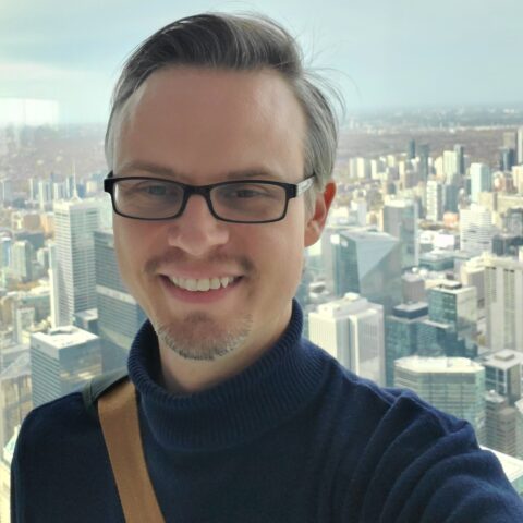 man smiling, skyscrapers in the background