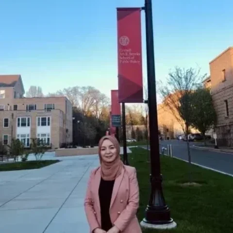 Rizwangul NurMuhammad standing in front of Brooks School Banner