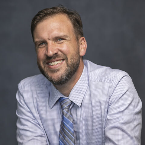 Nick Sanders in front of grey background