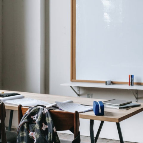 Desk and whiteboard in high school classroom