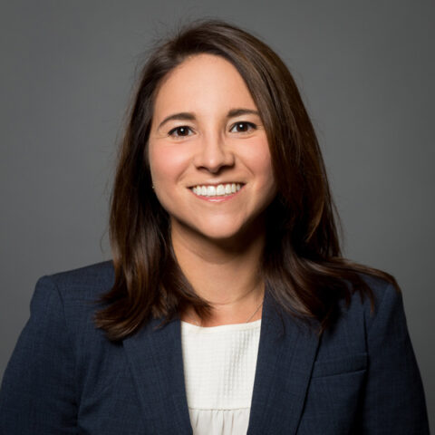 Woman smiling at camera wearing a navy blazer