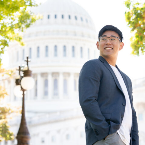 Student in blazer standing outside of Capital building