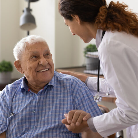 Senior-citizen-sitting-assisted-by-nurse